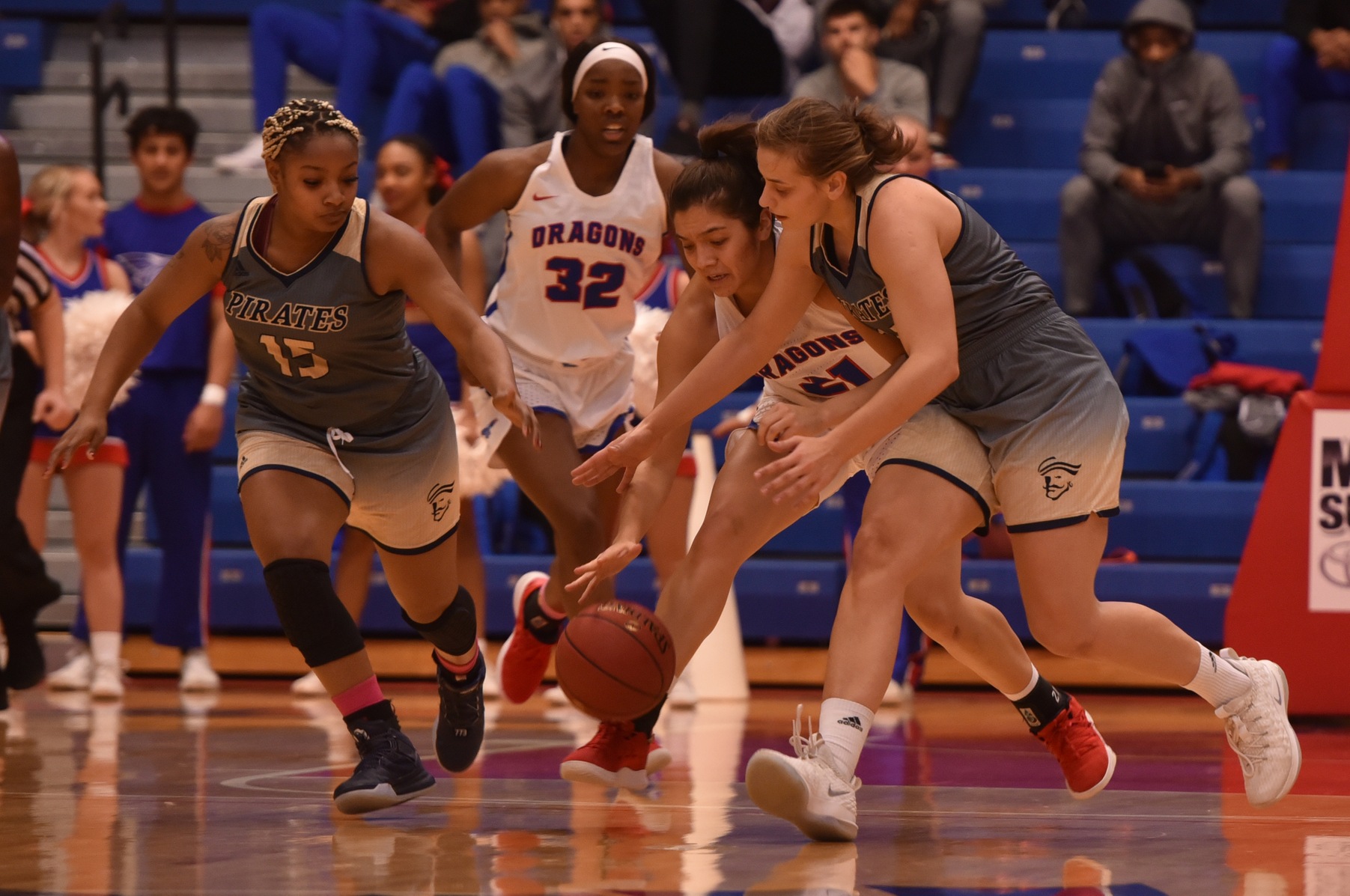 Independence's Cayla Trotter (15) and Anna Markowska (21) compete for a loose ball against Hutchinson's Milan Schimmel (21). Photo by Andrew Carpenter